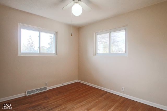 unfurnished room featuring ceiling fan, plenty of natural light, and wood-type flooring