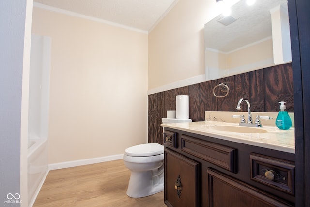 bathroom with toilet, wood-type flooring, ornamental molding, and a textured ceiling