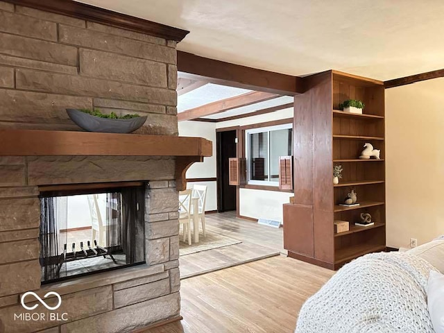 living room with beam ceiling, a fireplace, and light hardwood / wood-style flooring