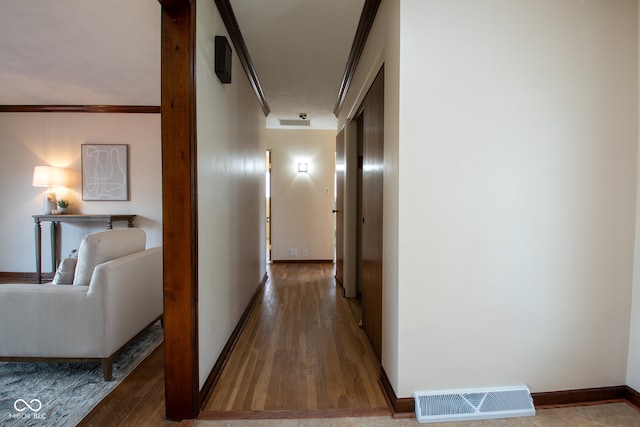 hall featuring wood-type flooring and ornamental molding