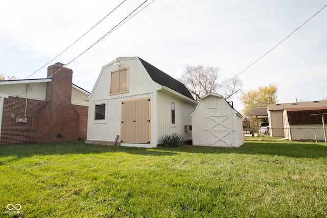 back of house with a yard and a storage shed