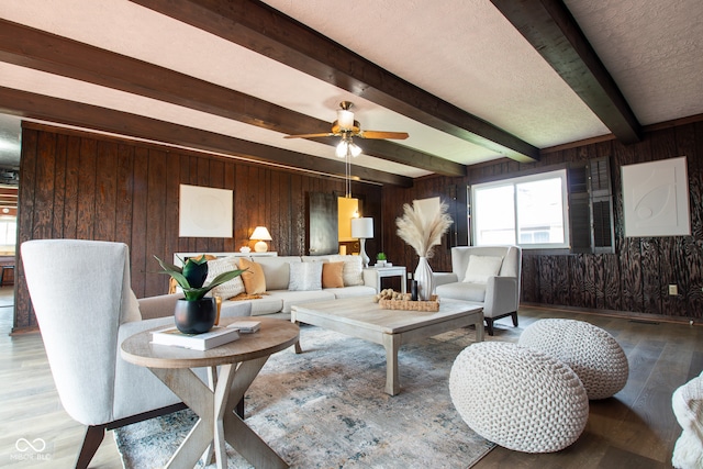 living room featuring beamed ceiling, wood-type flooring, and wood walls