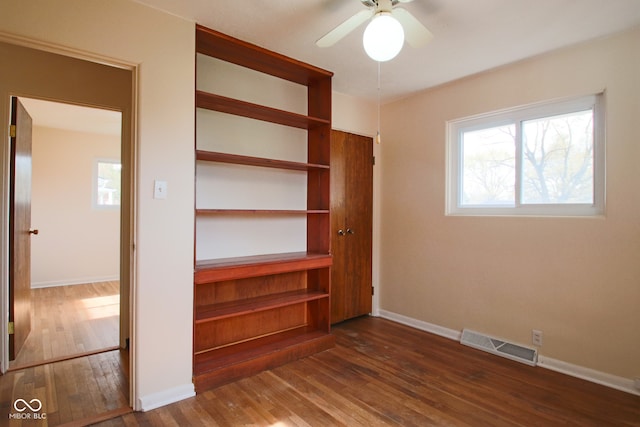 unfurnished bedroom with ceiling fan and dark hardwood / wood-style flooring