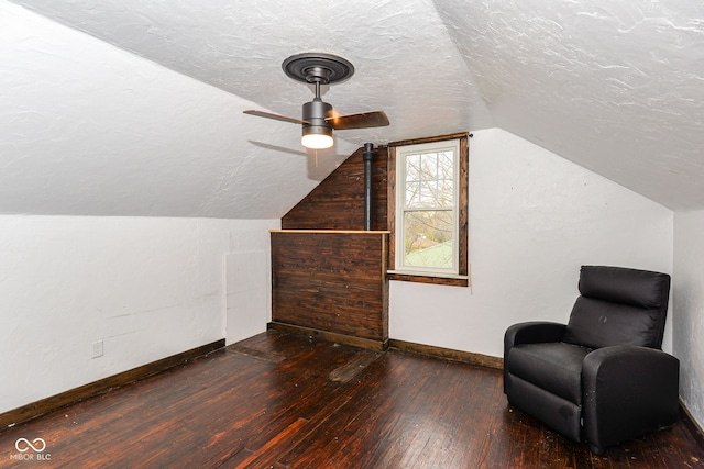 additional living space featuring a textured ceiling, dark hardwood / wood-style floors, ceiling fan, and lofted ceiling