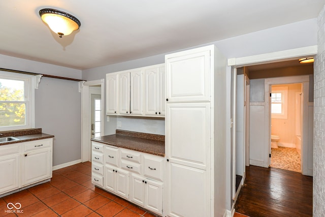 kitchen featuring a healthy amount of sunlight, wood-type flooring, and white cabinetry