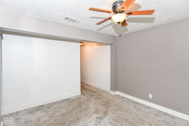 carpeted spare room featuring ceiling fan and a textured ceiling