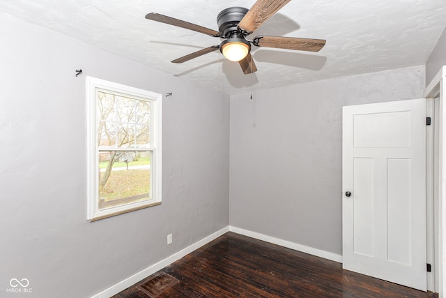 spare room with dark hardwood / wood-style floors and ceiling fan