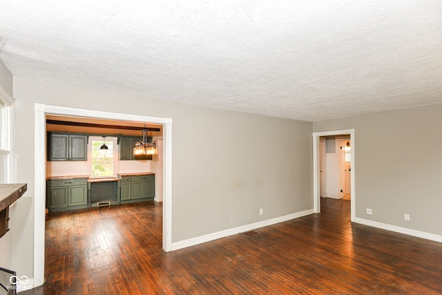 spare room featuring dark hardwood / wood-style flooring and a textured ceiling