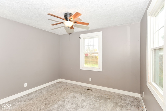 carpeted spare room featuring ceiling fan and a textured ceiling