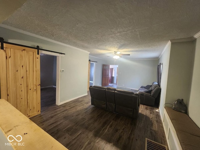 living room featuring a barn door, crown molding, and dark hardwood / wood-style floors