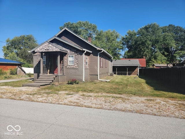 bungalow-style house featuring central AC unit and a front yard