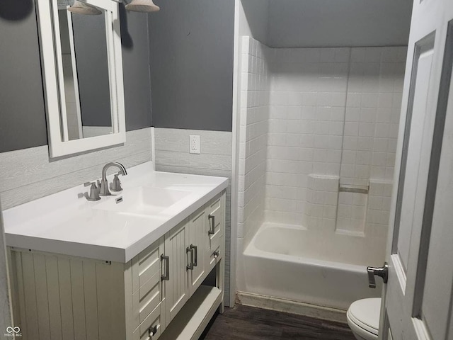 full bathroom with hardwood / wood-style floors, vanity, shower / bath combination, and toilet