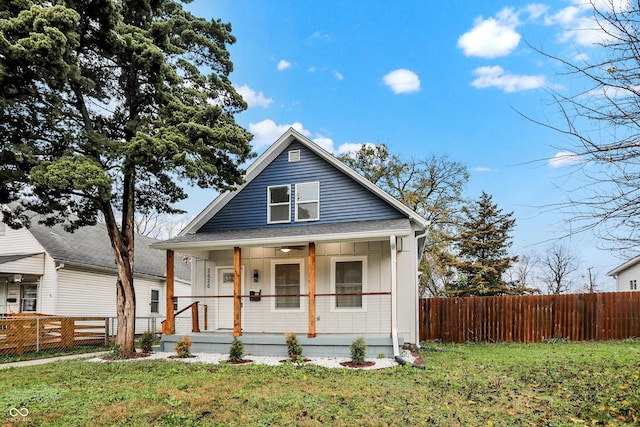 bungalow featuring covered porch and a front yard