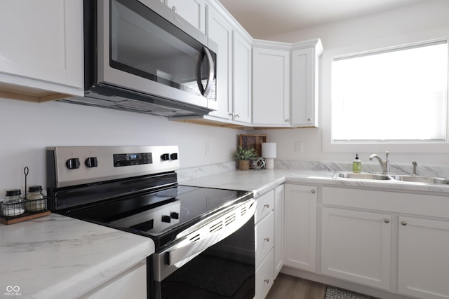 kitchen with a healthy amount of sunlight, stainless steel appliances, sink, and white cabinets