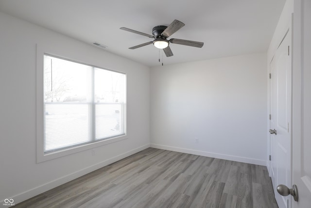 empty room with ceiling fan, a healthy amount of sunlight, and light hardwood / wood-style floors