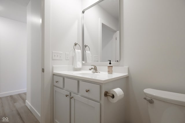 bathroom with vanity, hardwood / wood-style floors, and toilet