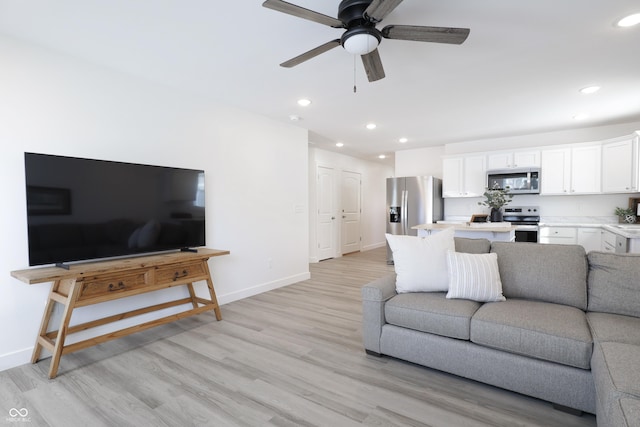 living room with ceiling fan and light wood-type flooring