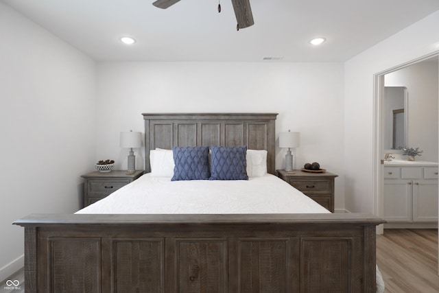 bedroom with ceiling fan, sink, ensuite bath, and light hardwood / wood-style floors