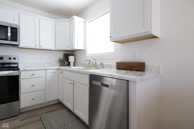 kitchen featuring appliances with stainless steel finishes, dark hardwood / wood-style floors, sink, and white cabinets