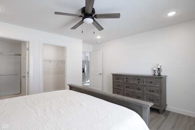 bedroom with stainless steel refrigerator with ice dispenser, ceiling fan, and light wood-type flooring