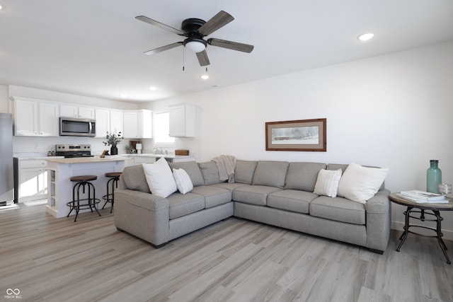 living room featuring ceiling fan and light wood-type flooring