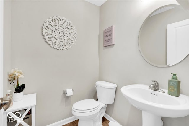 bathroom with hardwood / wood-style flooring, toilet, and sink