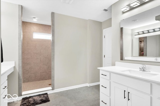 bathroom with a tile shower, tile patterned floors, and vanity