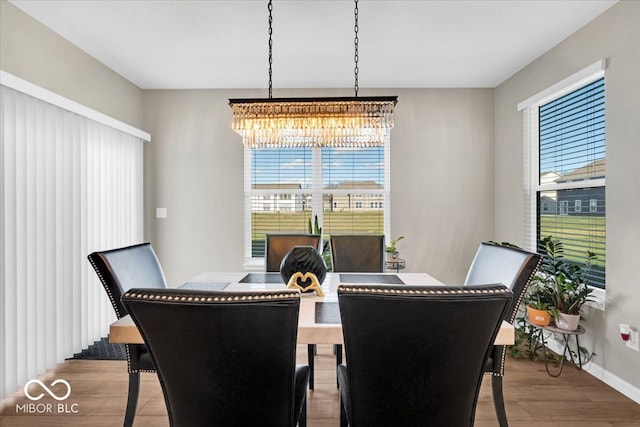 dining area featuring light hardwood / wood-style floors, plenty of natural light, and a notable chandelier