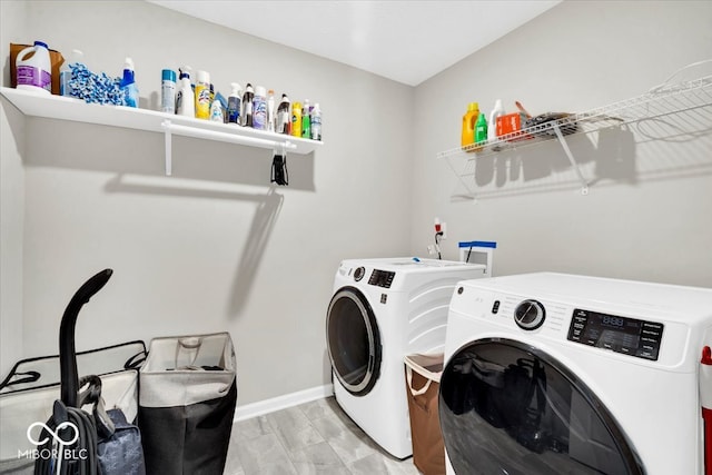 washroom with light hardwood / wood-style floors and washing machine and clothes dryer