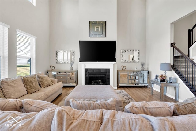 living room featuring a high ceiling and light hardwood / wood-style flooring