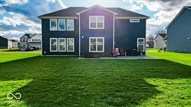 rear view of property with a yard and a patio