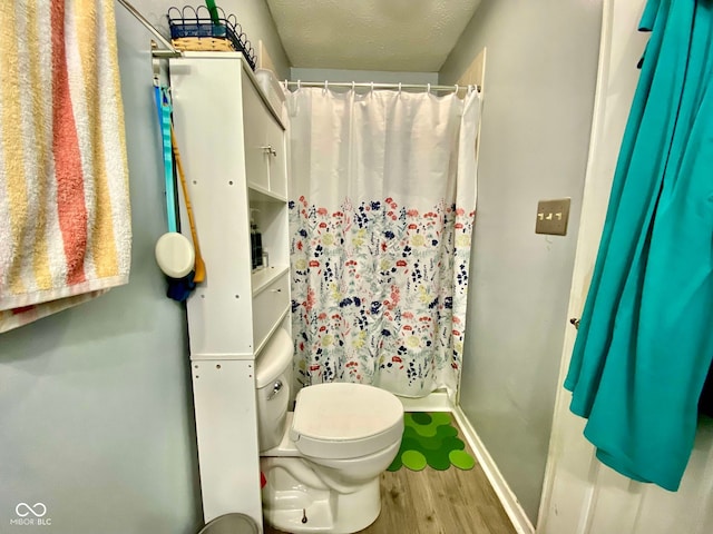 bathroom featuring hardwood / wood-style floors, toilet, and a textured ceiling