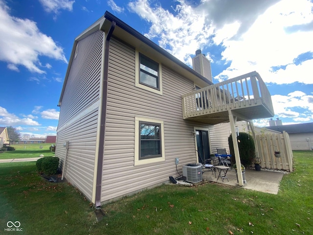 rear view of house featuring a lawn, a patio, and central AC