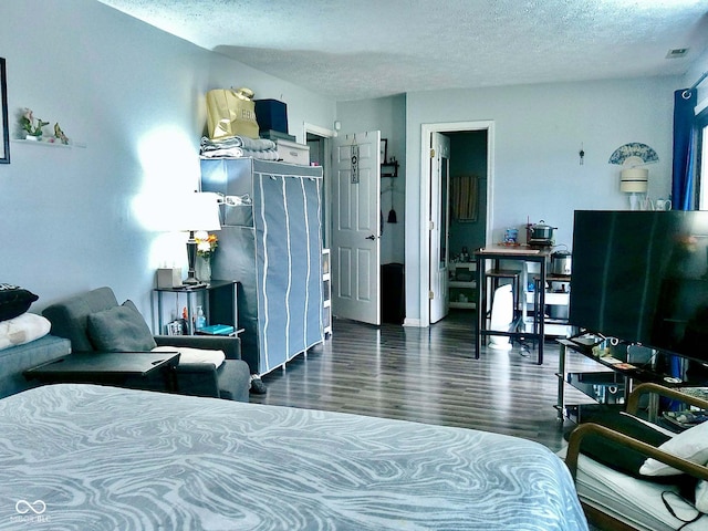 bedroom with dark wood-type flooring and a textured ceiling