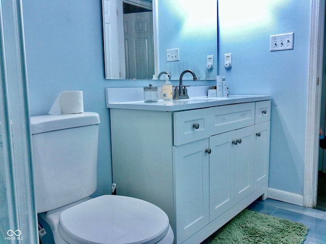 bathroom with tile patterned flooring, vanity, and toilet