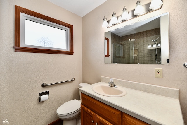 bathroom featuring vanity, toilet, and walk in shower