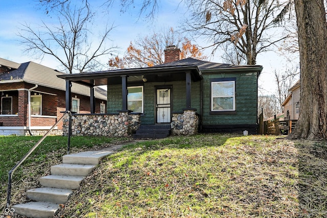 view of front of house with a front yard and a porch