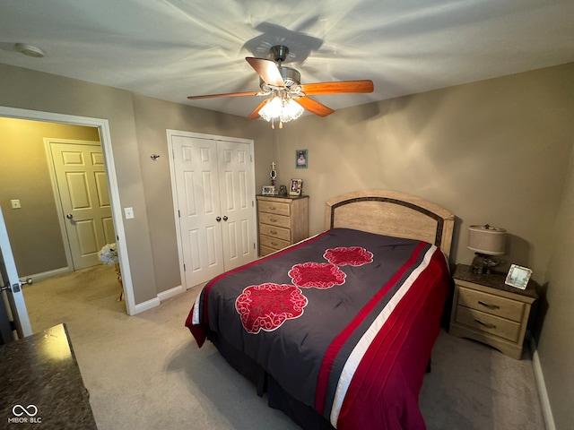 carpeted bedroom with ceiling fan and a closet