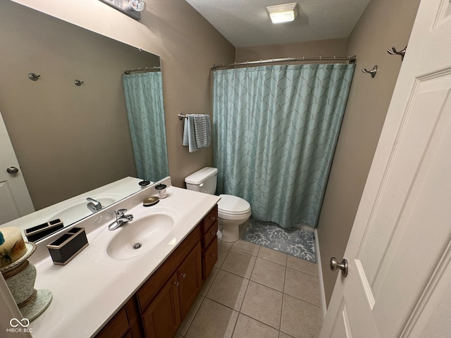 bathroom with a shower with curtain, vanity, a textured ceiling, tile patterned flooring, and toilet