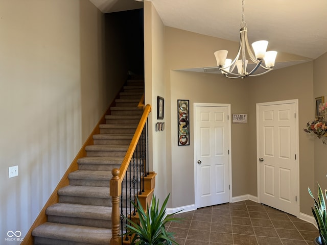 staircase with tile patterned flooring, a notable chandelier, and lofted ceiling