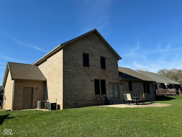 rear view of house featuring a lawn, a patio, and central AC unit