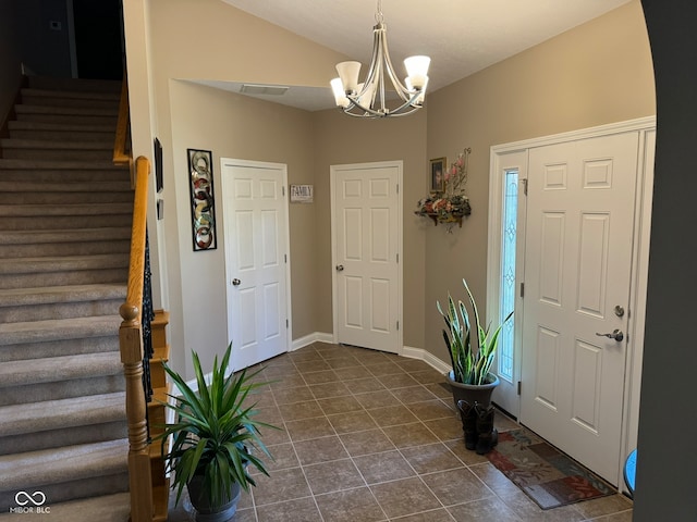 tiled foyer with a chandelier and lofted ceiling