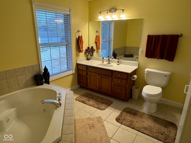 bathroom featuring toilet, vanity, a relaxing tiled tub, and tile patterned floors