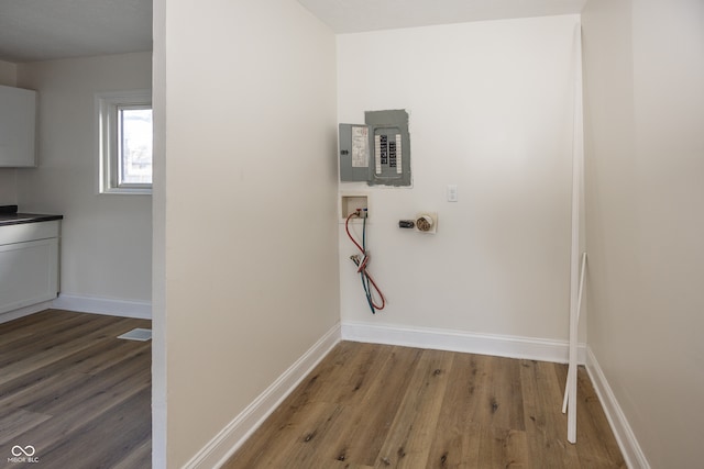 washroom with cabinets, washer hookup, electric panel, and hardwood / wood-style flooring