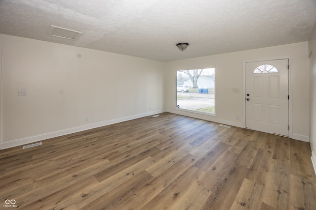 entryway with hardwood / wood-style floors and a textured ceiling