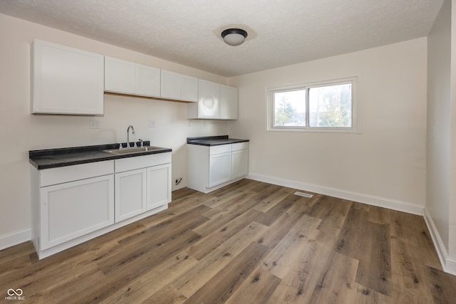 kitchen featuring white cabinetry, sink, and hardwood / wood-style flooring