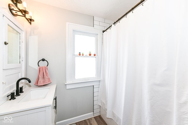 bathroom with vanity, shower / bath combination with curtain, a textured ceiling, and hardwood / wood-style flooring