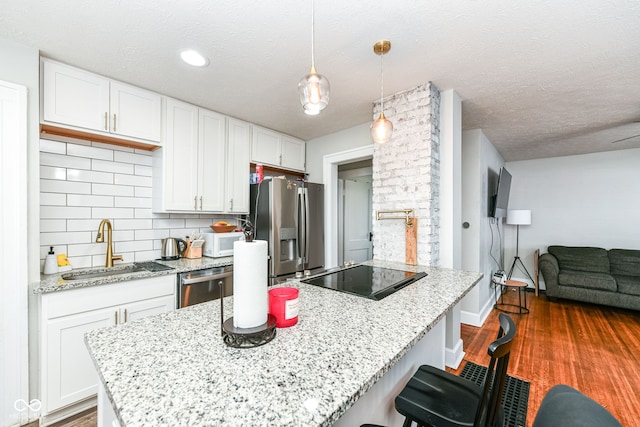 kitchen featuring white cabinetry, sink, stainless steel appliances, dark hardwood / wood-style floors, and backsplash