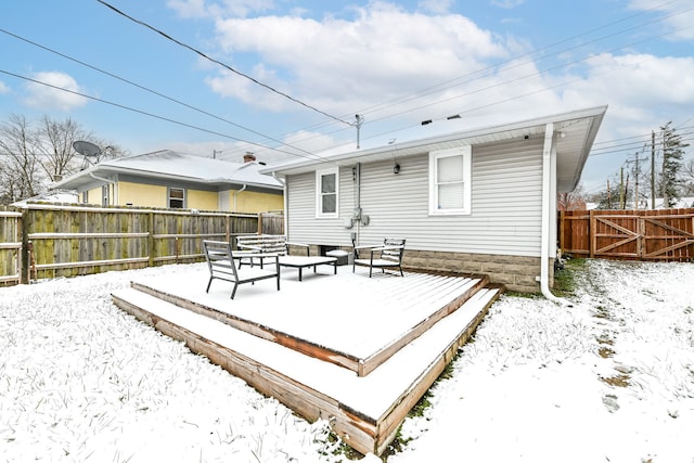 snow covered rear of property featuring a deck