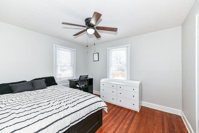 bedroom featuring a textured ceiling, multiple windows, ceiling fan, and dark hardwood / wood-style floors